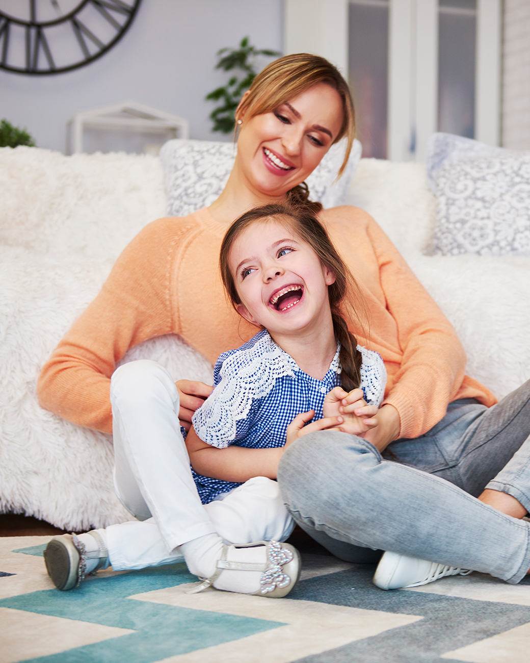 A happy mom and her little daughter having fun at home